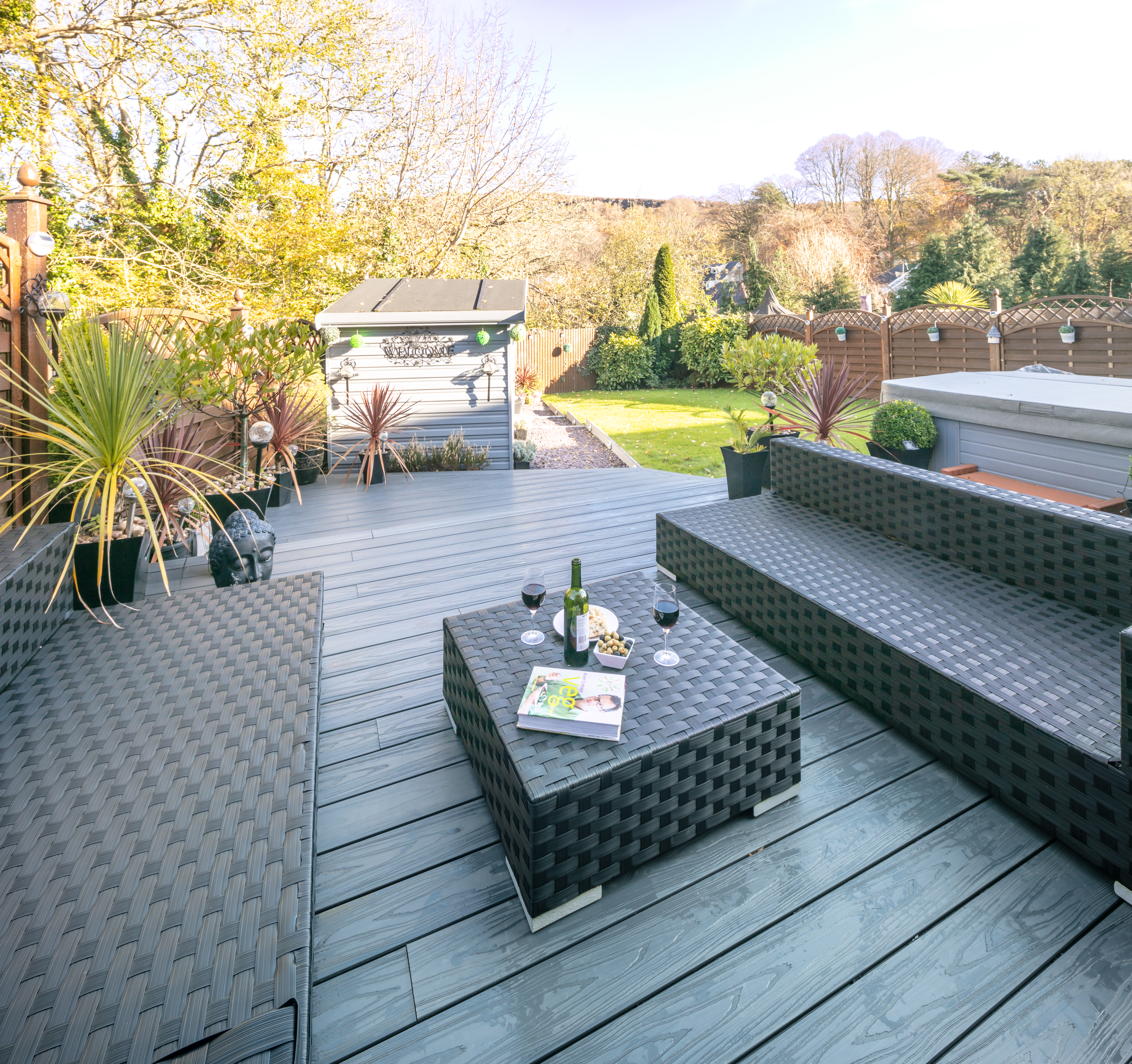 Top down view of Alchemy composite decking with garden furniture and potted plants in background